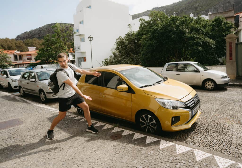 Caleb posing in front of our small rental car in Madeira, Portugal