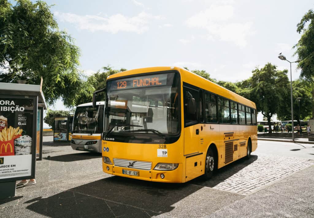 a large yellow public bus at the bus stop in Funchal, Madeira