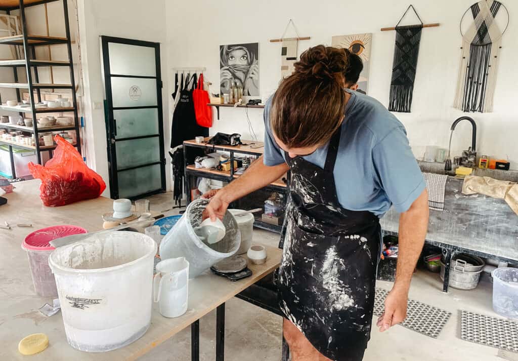 Caleb glazing his own ceramic mug at a pottery calls in Canggu