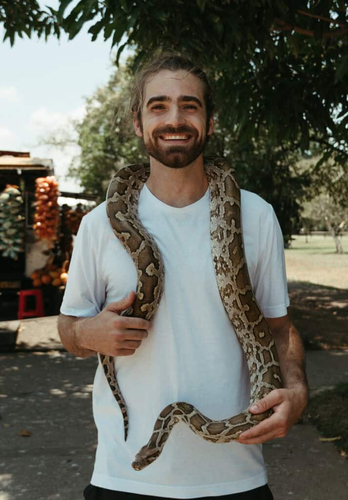 Caleb holding a massive python around his neck